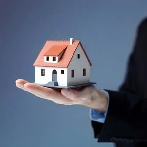 A person holding model of a house